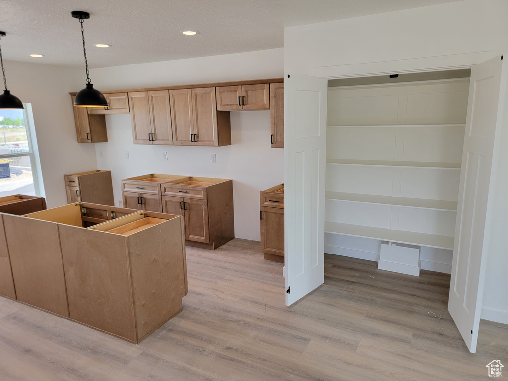Kitchen featuring light wood finished floors, decorative light fixtures, and recessed lighting