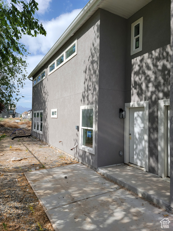 Rear view of house with stucco siding and a patio