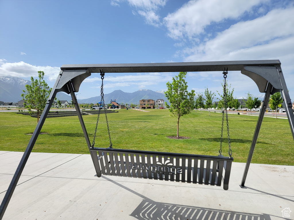 Surrounding community with a mountain view and a yard