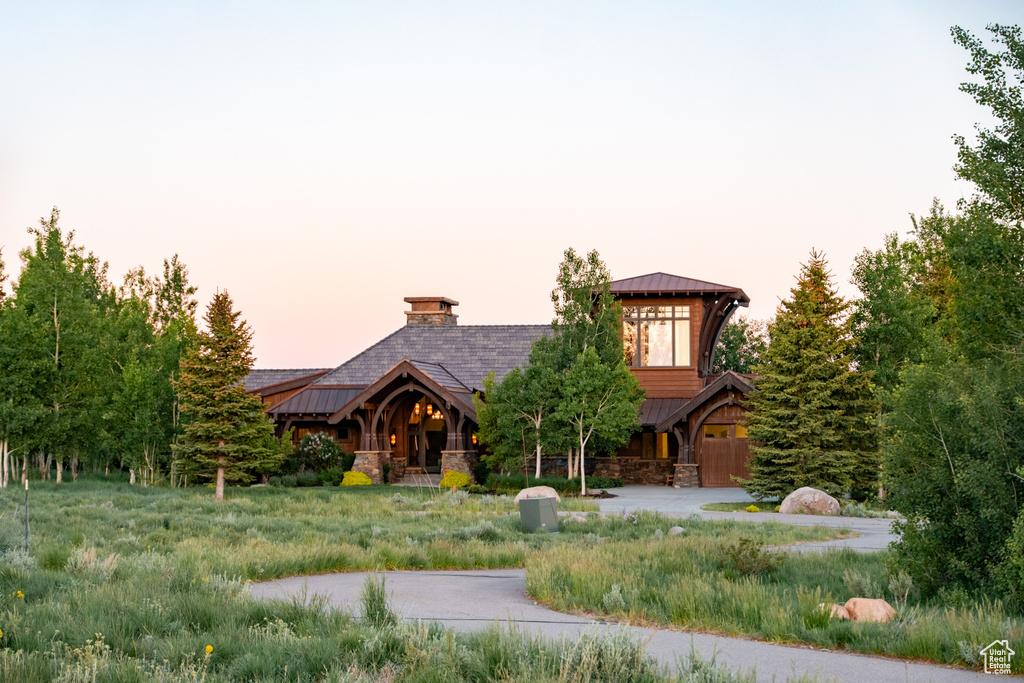 Log-style house with stone siding, a standing seam roof, and a metal roof
