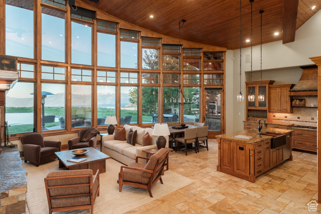 Living area featuring wooden ceiling, high vaulted ceiling, a mountain view, stone tile flooring, and recessed lighting