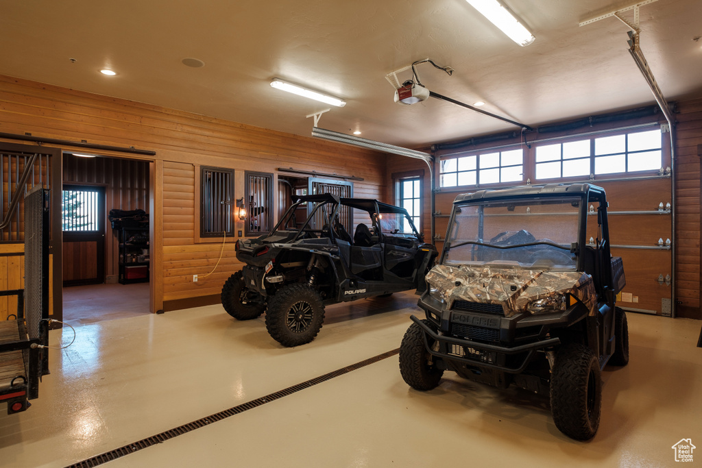 Garage featuring a garage door opener and wooden walls