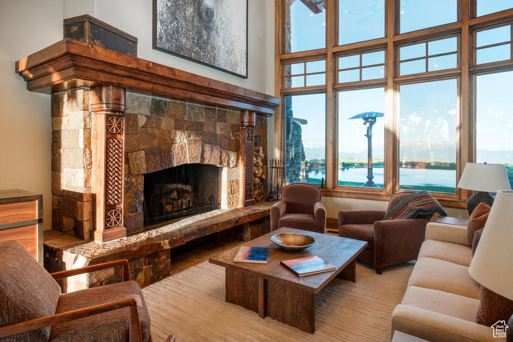 Living room featuring a fireplace with raised hearth and a high ceiling
