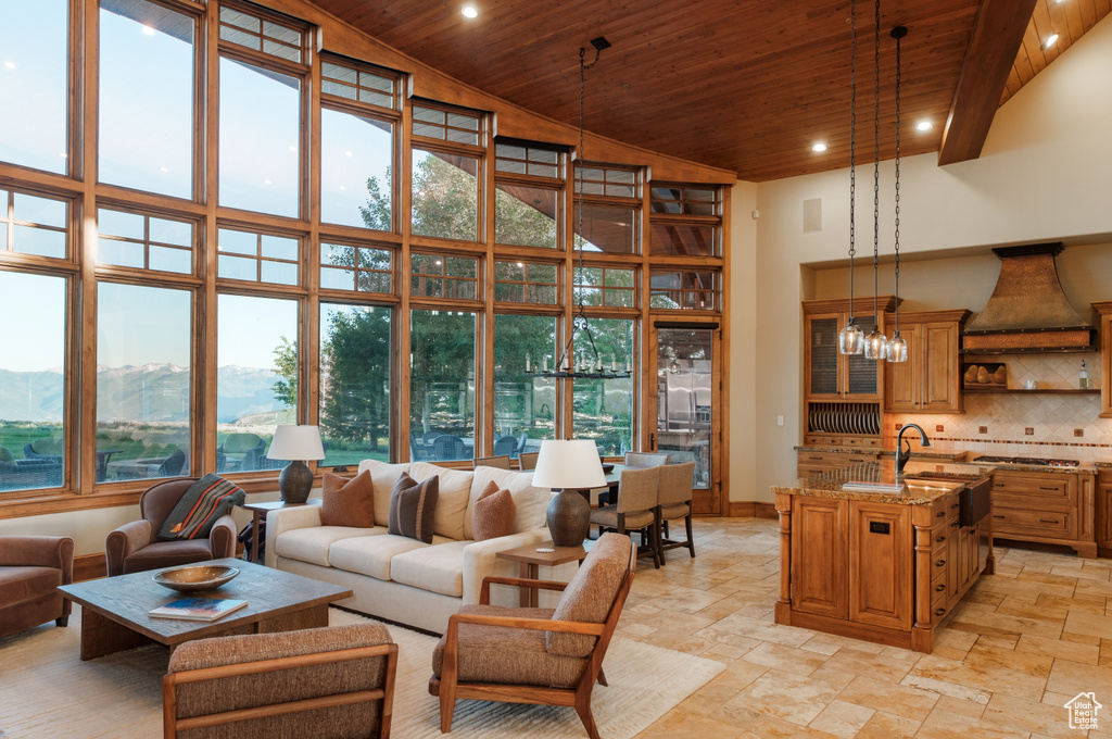 Living area with wooden ceiling, a towering ceiling, recessed lighting, stone tile flooring, and a mountain view