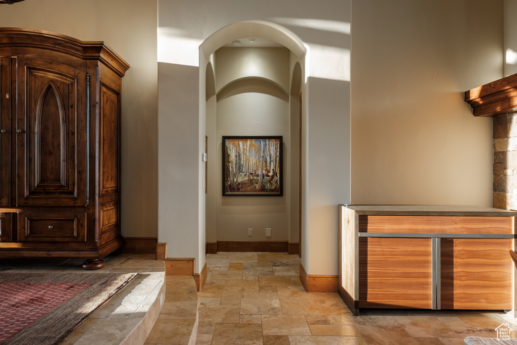 Hallway featuring stone tile flooring and baseboards