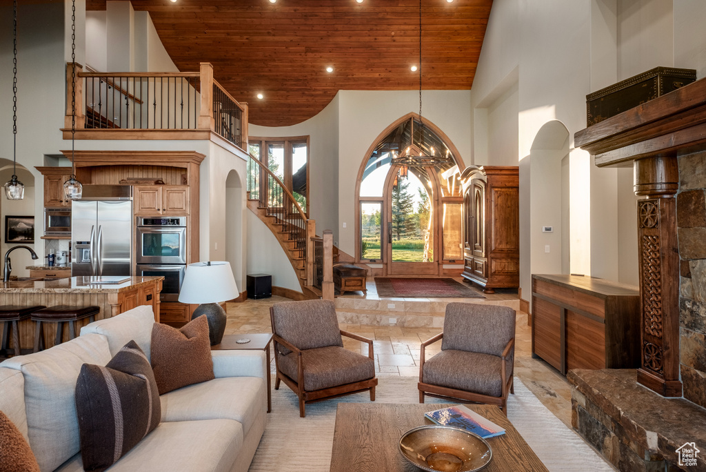 Living area featuring high vaulted ceiling, wooden ceiling, stairway, recessed lighting, and arched walkways
