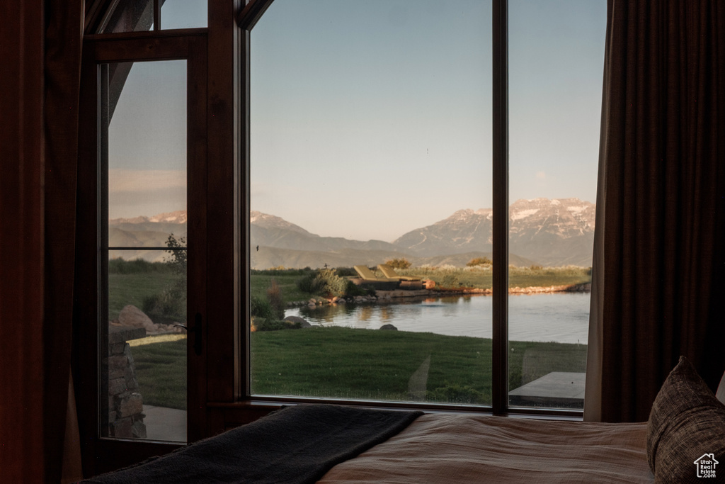 Bedroom with a water and mountain view and multiple windows