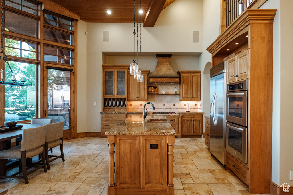Kitchen with a high ceiling, stainless steel appliances, stone tile flooring, open shelves, and wood ceiling