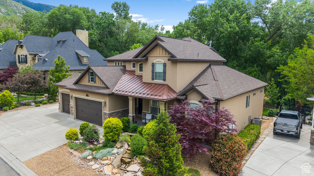 Craftsman house featuring stucco siding, driveway, covered porch, stone siding, and a chimney