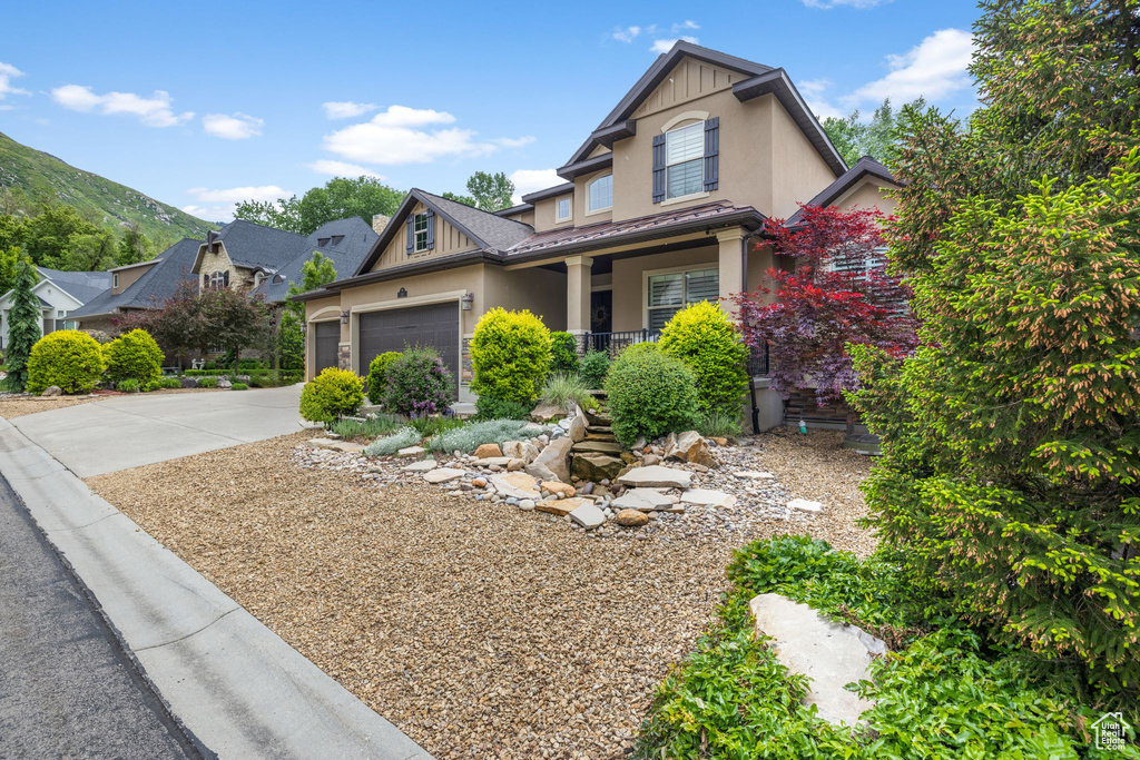 Craftsman house featuring covered porch, stucco siding, driveway, and a garage