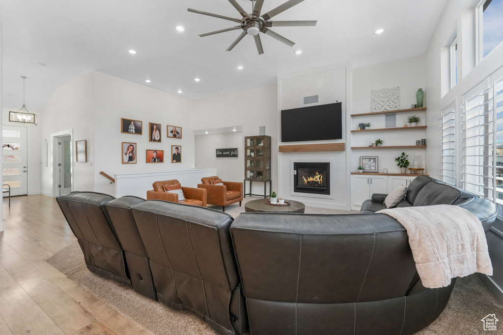 Living room featuring recessed lighting, a glass covered fireplace, a ceiling fan, and light wood finished floors