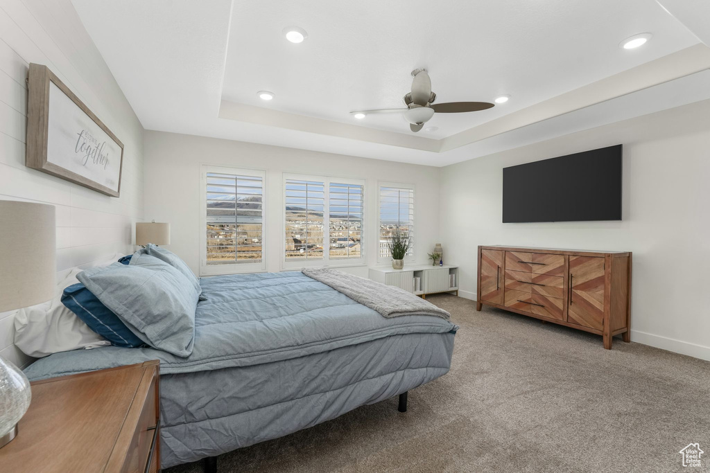 Bedroom featuring baseboards, carpet, recessed lighting, a raised ceiling, and a ceiling fan
