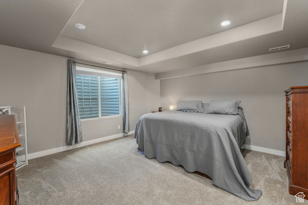 Carpeted bedroom featuring recessed lighting, visible vents, a raised ceiling, and baseboards