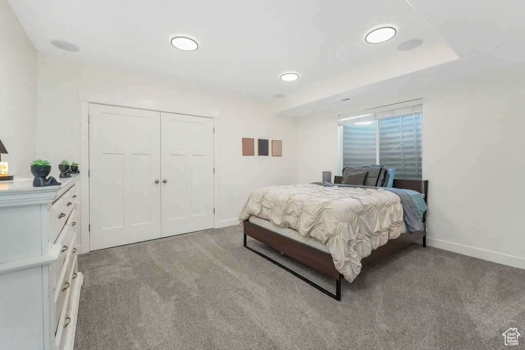Bedroom featuring baseboards, a closet, and light carpet