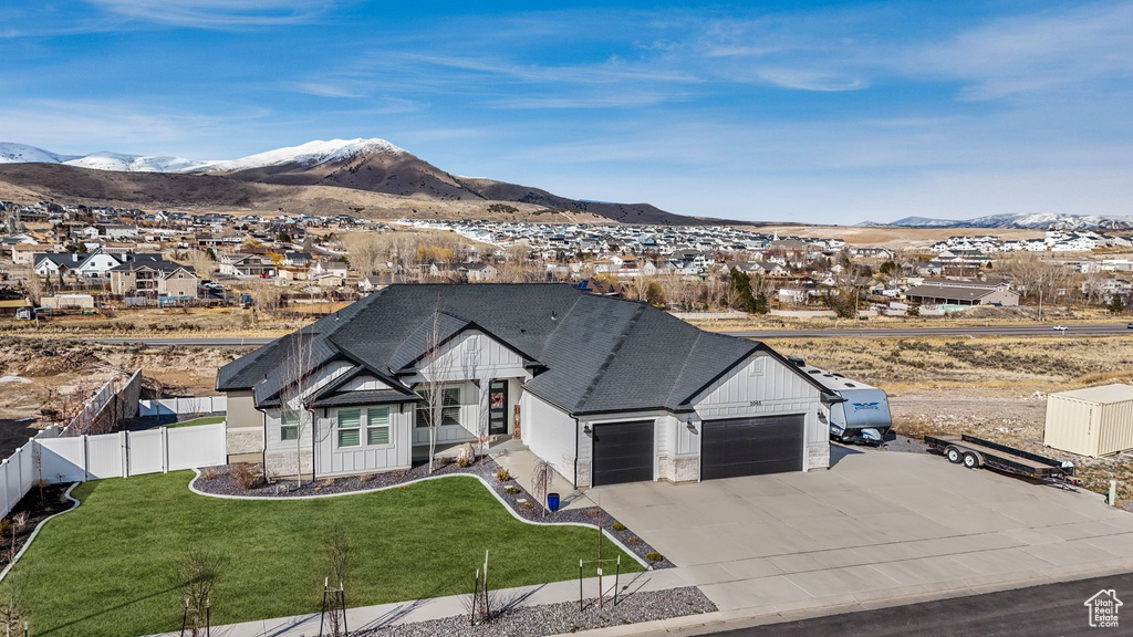 View of front of home featuring a mountain view, board and batten siding, and fence