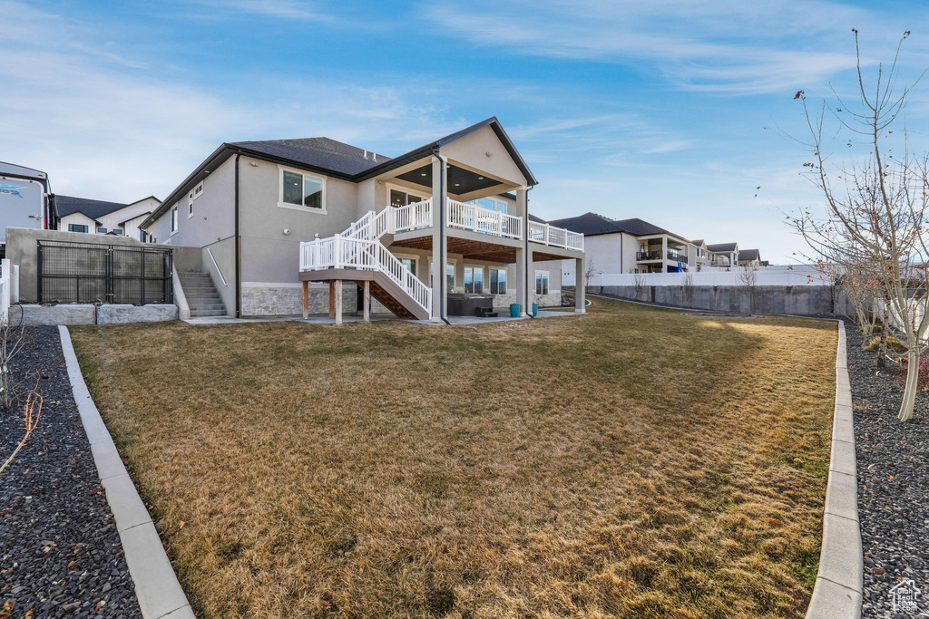 Rear view of property featuring stairway, a lawn, a fenced backyard, and a deck