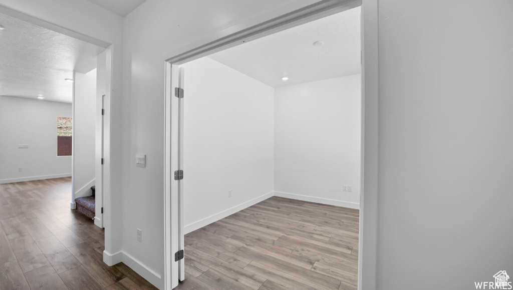 Corridor featuring stairs, baseboards, and wood finished floors