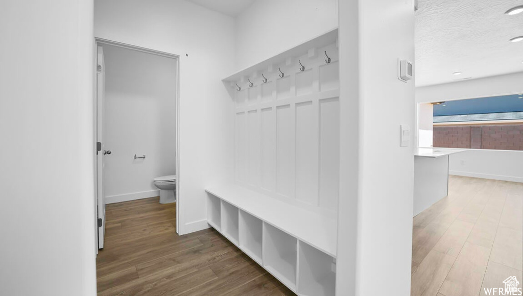Mudroom featuring wood finished floors, baseboards, and a textured ceiling