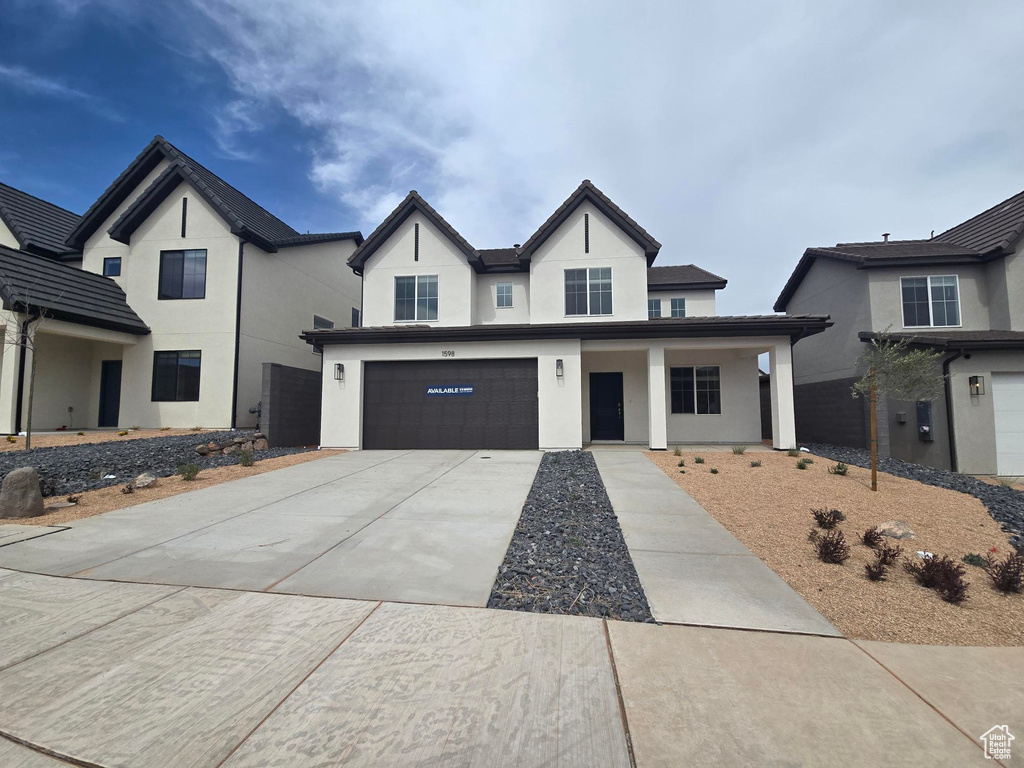 Modern farmhouse featuring driveway, stucco siding, and an attached garage