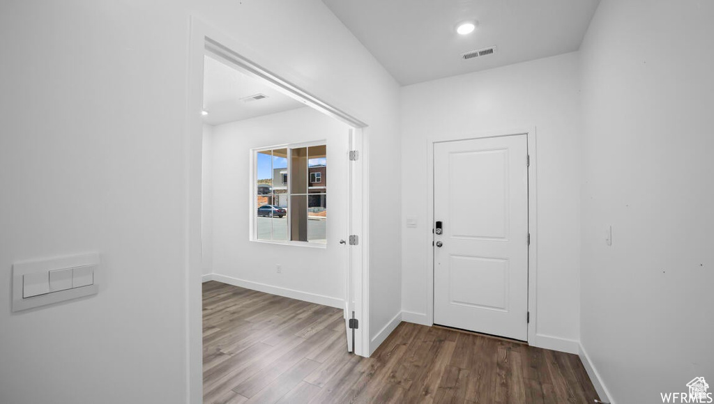 Foyer entrance with recessed lighting, visible vents, baseboards, and wood finished floors