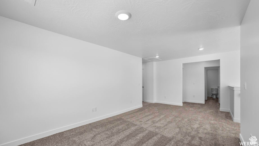 Carpeted spare room with baseboards and a textured ceiling