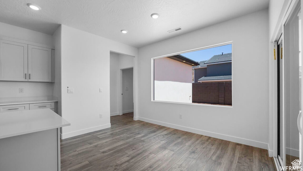 Unfurnished dining area featuring recessed lighting, visible vents, baseboards, and wood finished floors