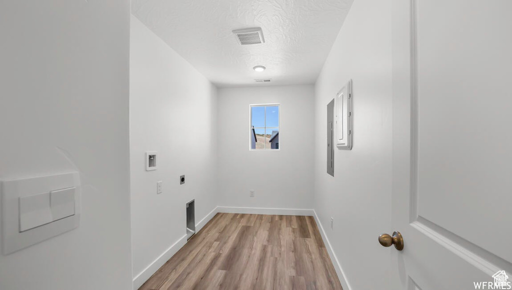 Laundry room with washer hookup, laundry area, light wood-style flooring, hookup for an electric dryer, and a textured ceiling