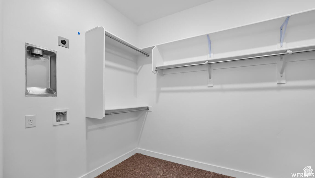 Walk in closet featuring dark colored carpet