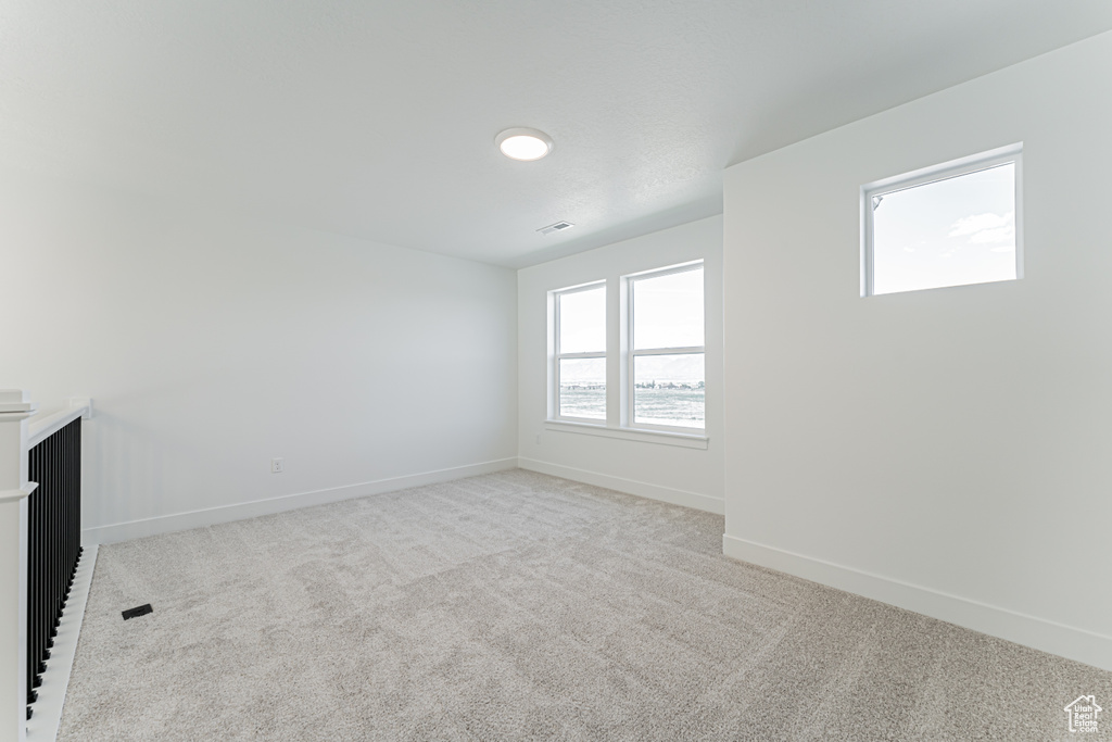 Spare room with light carpet and baseboards