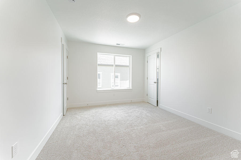 Empty room with baseboards and light carpet