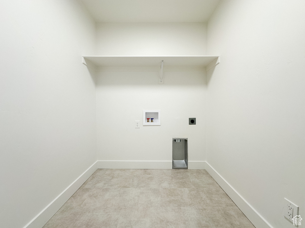 Washroom featuring baseboards, washer hookup, light carpet, laundry area, and electric dryer hookup