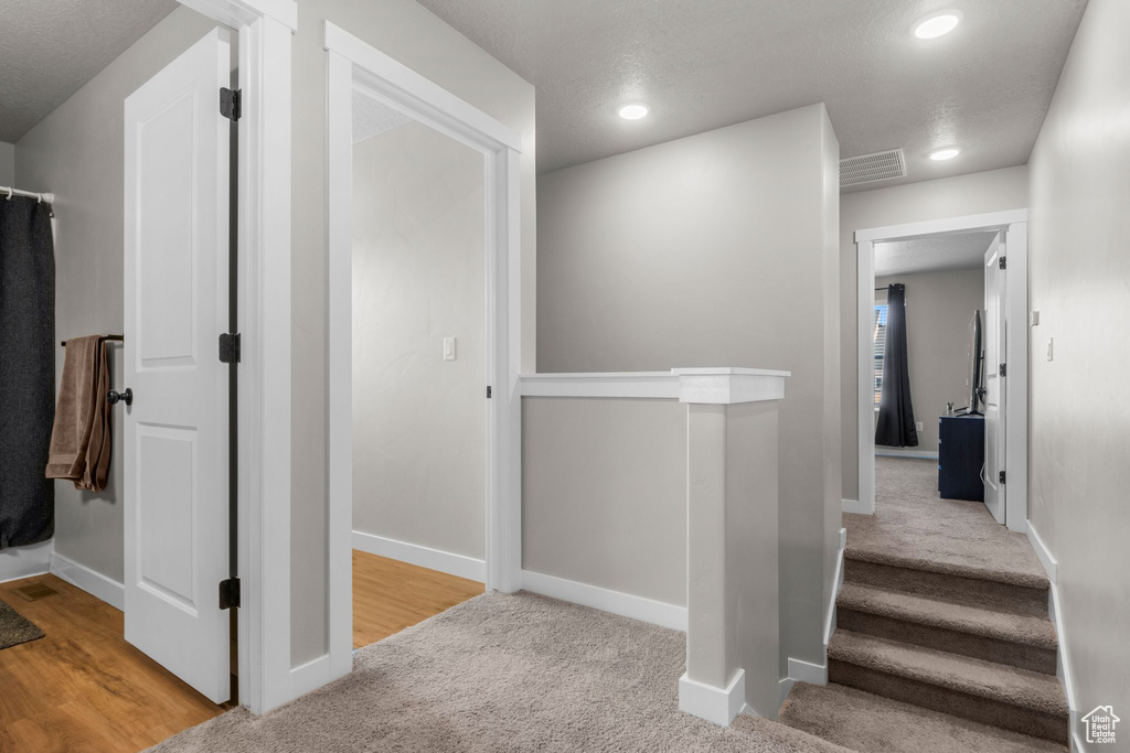 Corridor with carpet flooring, recessed lighting, visible vents, and baseboards