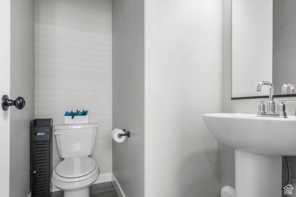 Bathroom with toilet, baseboards, and a sink