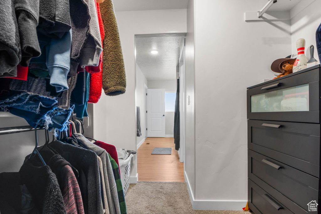 Walk in closet featuring light colored carpet