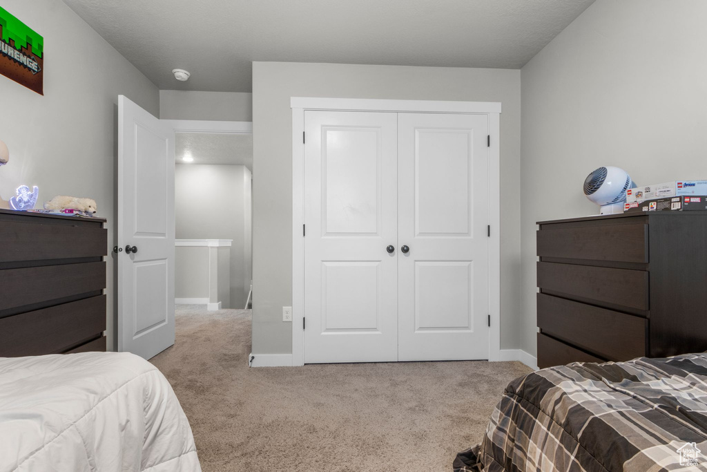 Bedroom with carpet, a closet, and baseboards