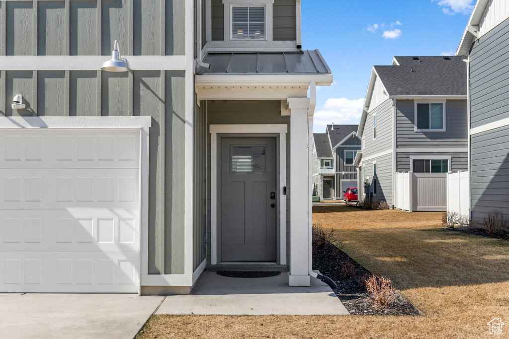 Property entrance featuring a standing seam roof, a garage, and metal roof