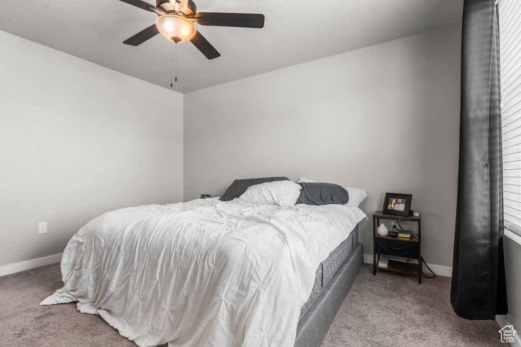 Carpeted bedroom with baseboards and a ceiling fan