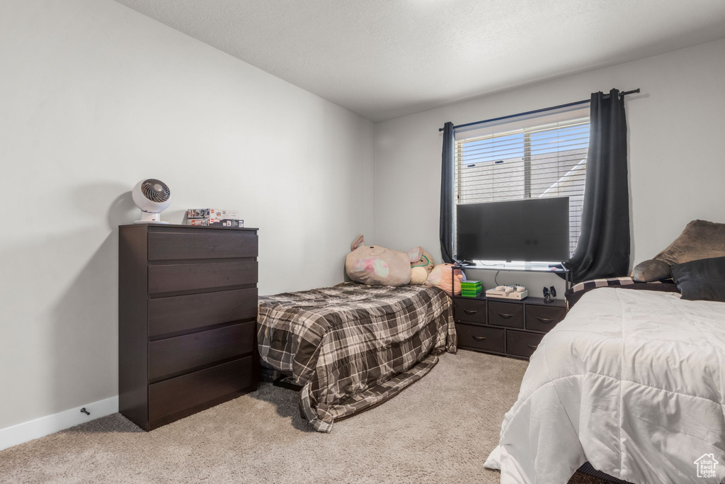 Bedroom with baseboards and light carpet