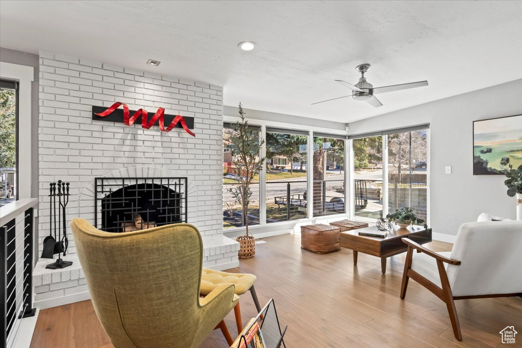 Interior space with a fireplace, plenty of natural light, wood finished floors, and baseboards