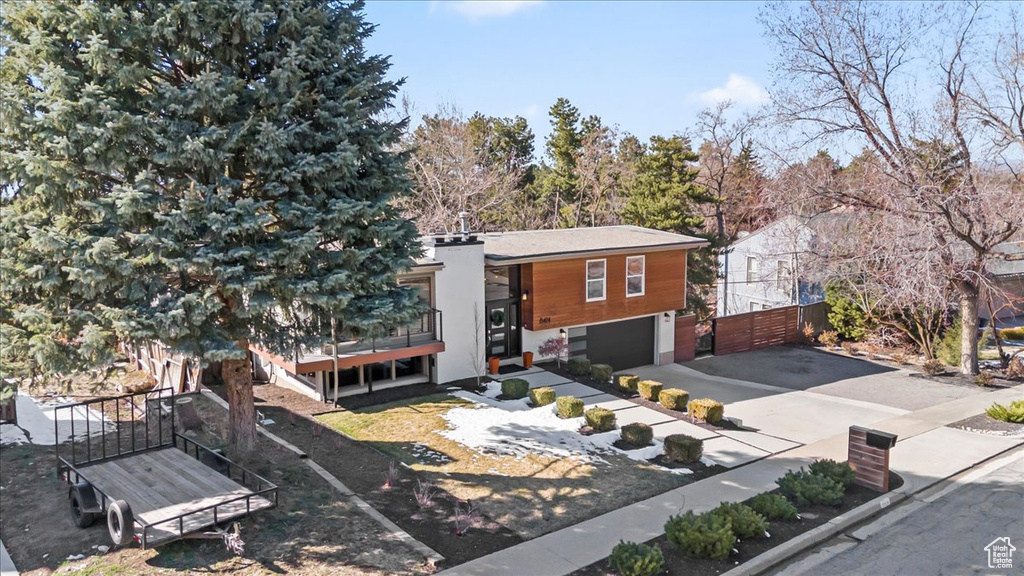 Modern home with a garage, driveway, and fence