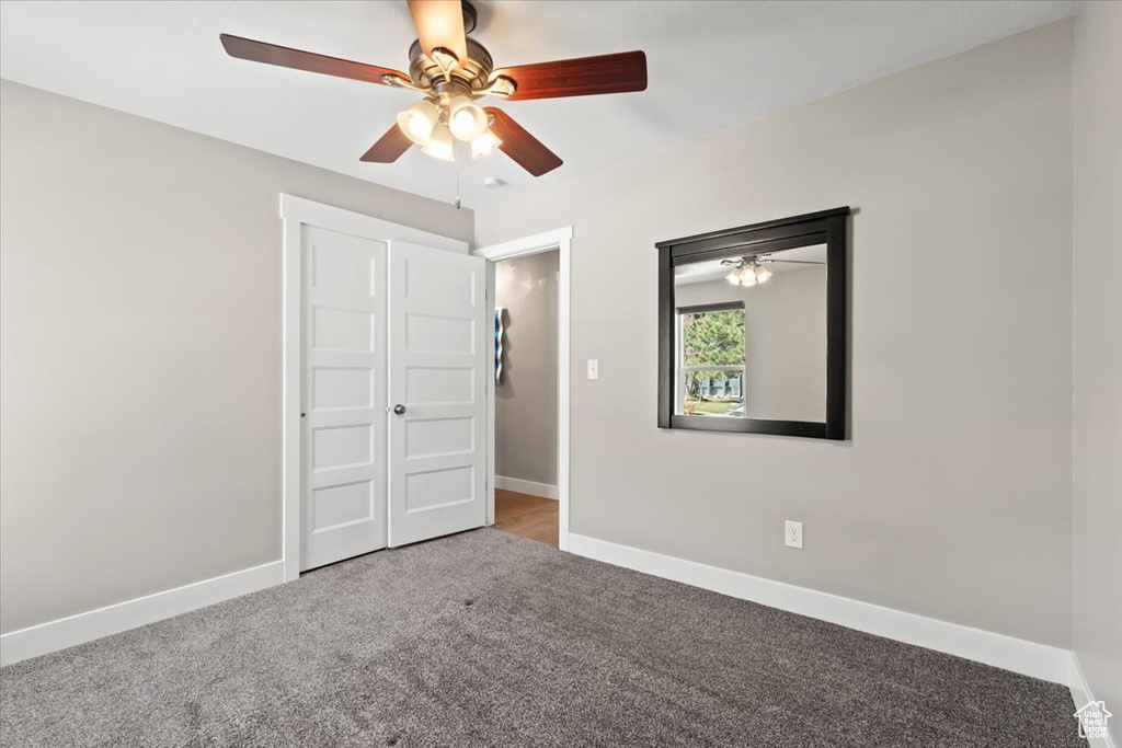 Unfurnished bedroom featuring baseboards, carpet floors, and ceiling fan