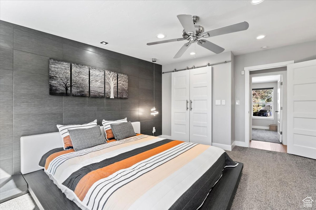 Carpeted bedroom with recessed lighting, baseboards, a barn door, and ceiling fan