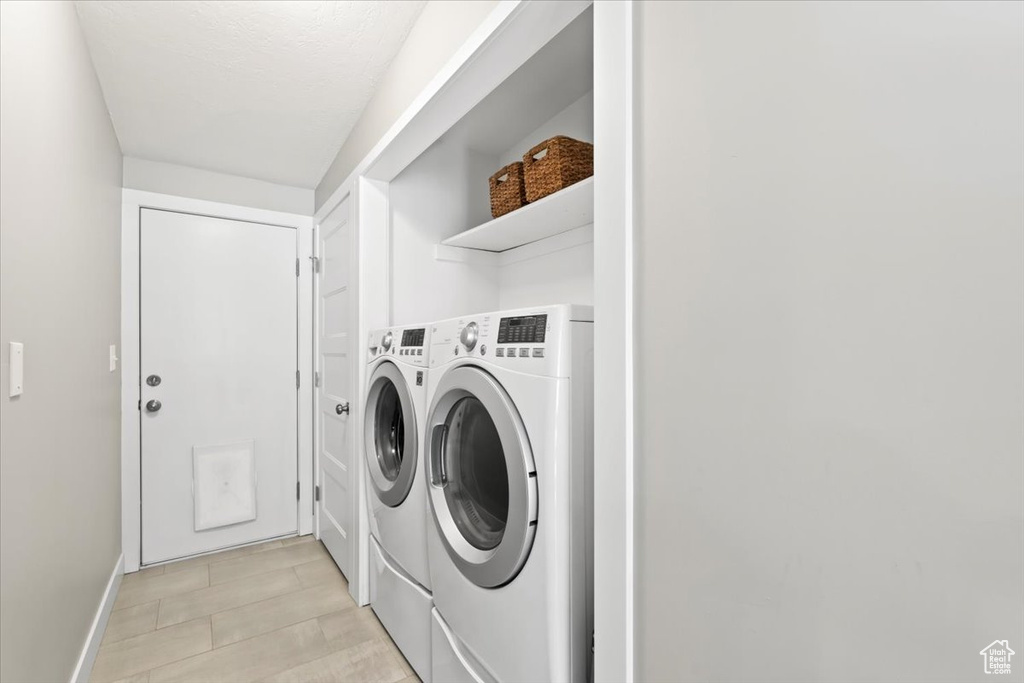 Washroom with baseboards, laundry area, and washing machine and clothes dryer