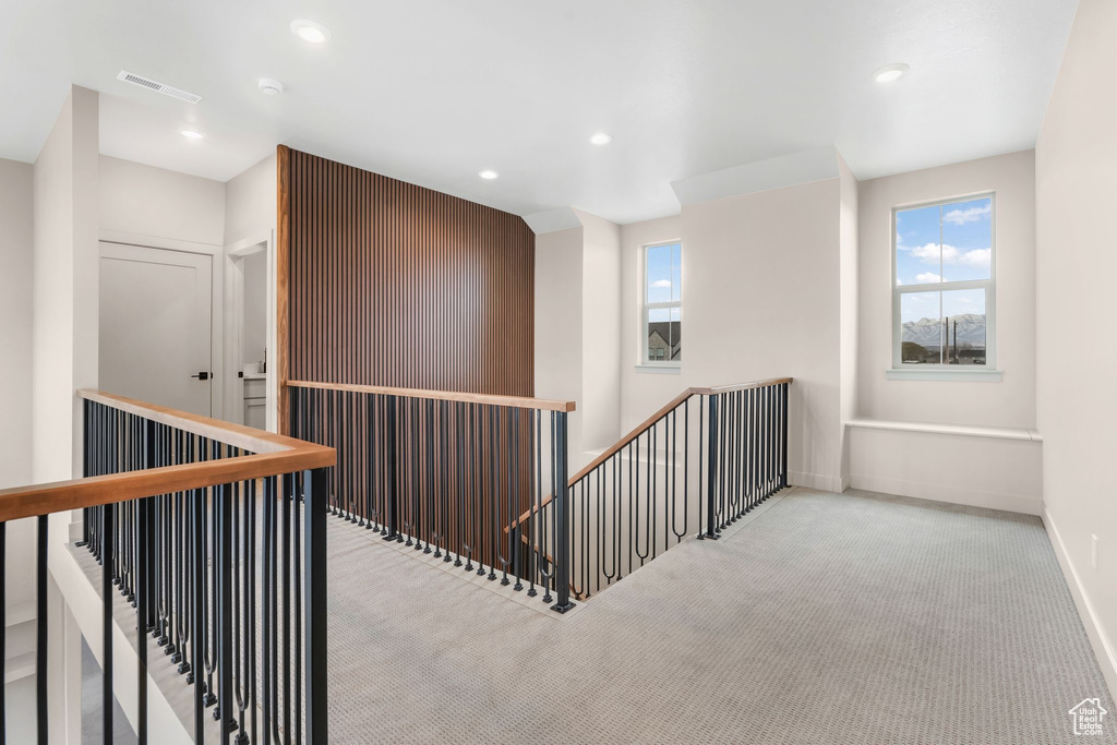 Hall with visible vents, baseboards, recessed lighting, carpet flooring, and an upstairs landing