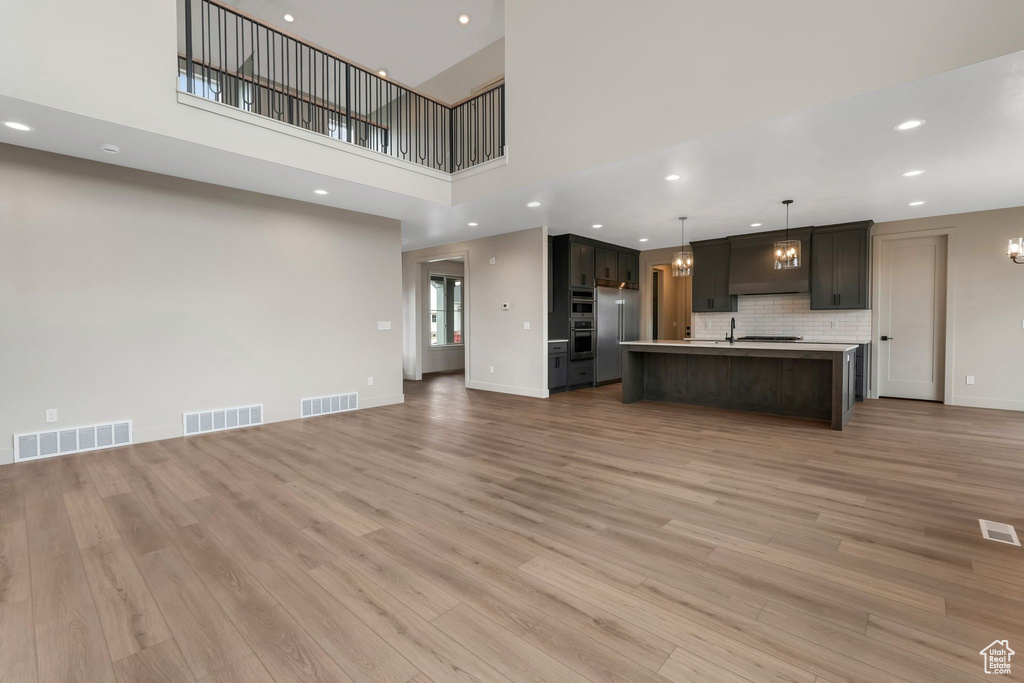 Unfurnished living room featuring recessed lighting, visible vents, and light wood-style floors