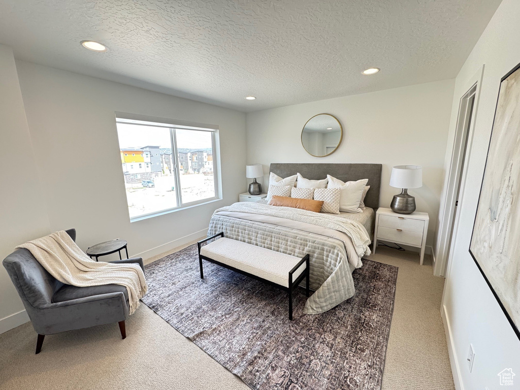 Carpeted bedroom with recessed lighting, a textured ceiling, and baseboards