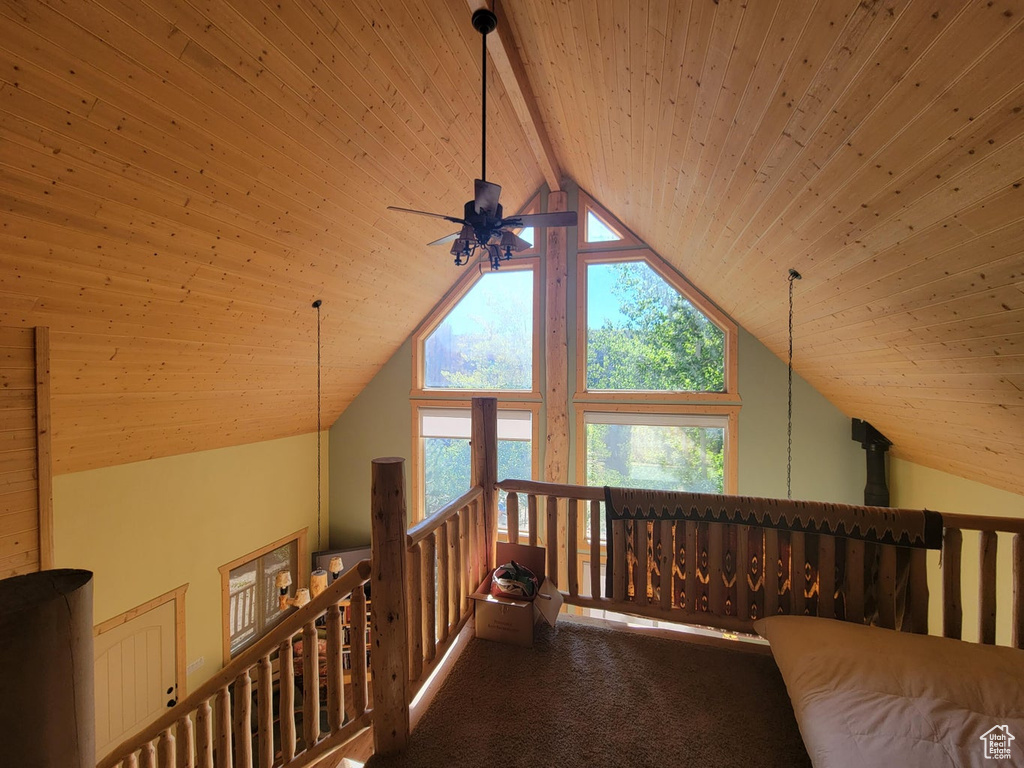 Interior space featuring lofted ceiling with beams, wooden ceiling, and carpet flooring