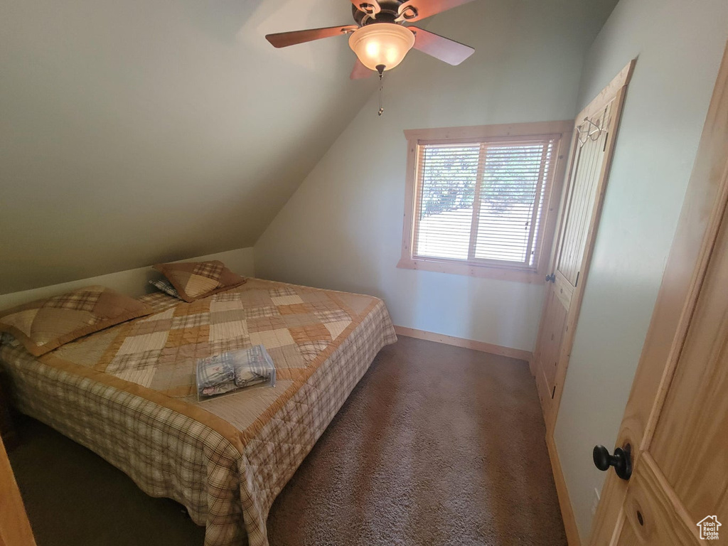 Bedroom featuring carpet floors, ceiling fan, baseboards, and vaulted ceiling