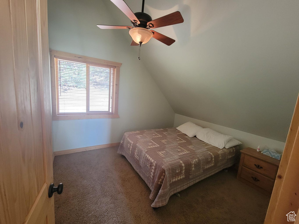 Bedroom with ceiling fan, baseboards, lofted ceiling, and carpet