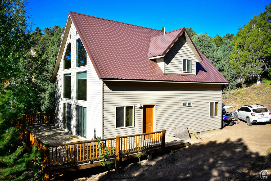 Rear view of property with a deck, crawl space, and metal roof